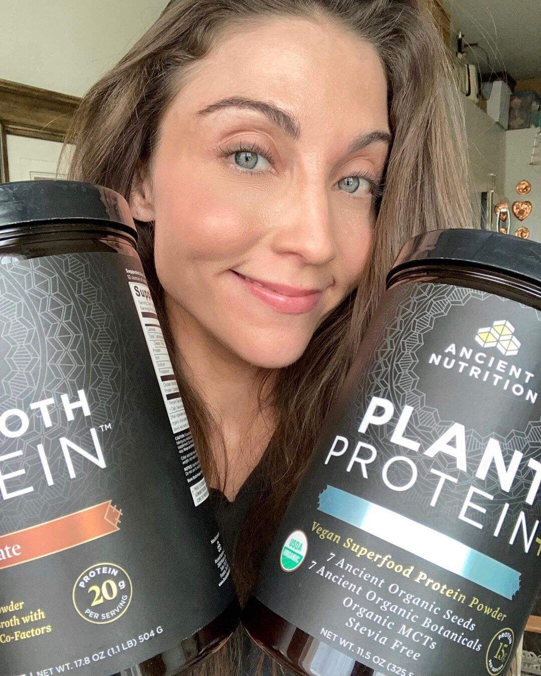 Mary Padian holding 2 protein powder for giveaway